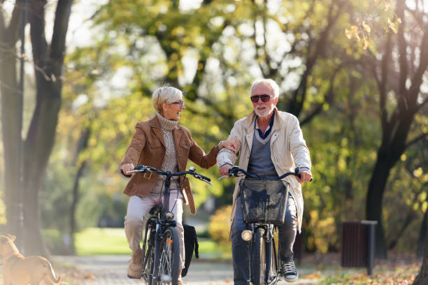 istock Cheerful active senior couple with bicycle in public park together having fun 1307713937