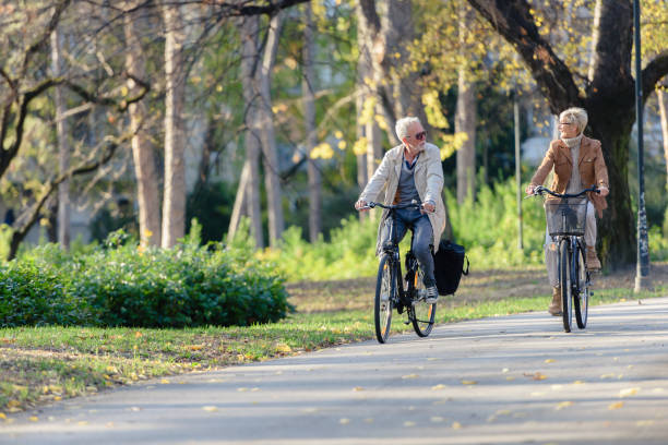 istock Cheerful active senior couple with bicycle in public park together having fun 1307714054