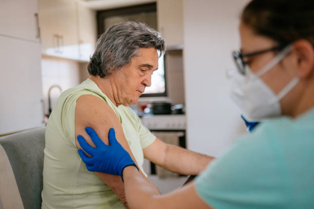 istock Patient getting vaccination at home - mature man 1307715345