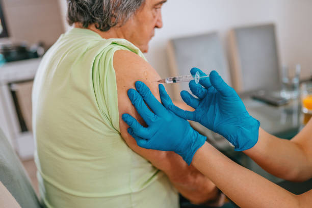 istock Patient getting vaccination at home - mature man 1307715358