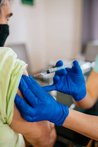 istock Patient getting vaccination at home - mature man 1307715412