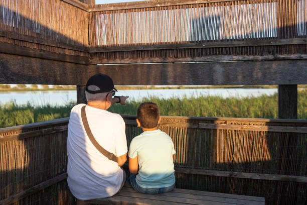 Gandfather and grandson on a bird-watching place
