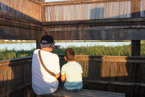 Gandfather and grandson on a bird-watching place