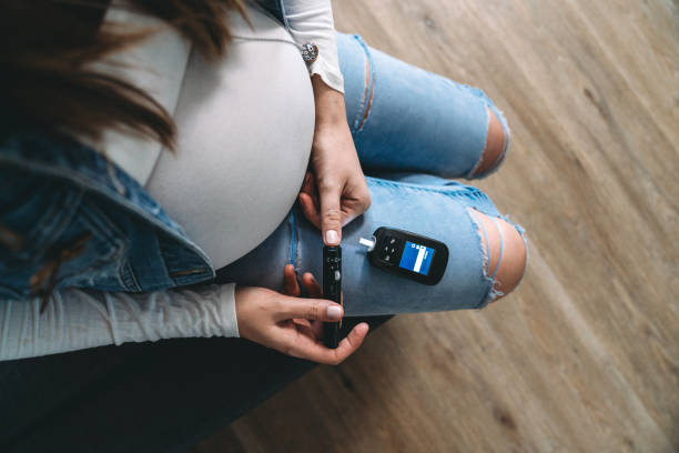 mujer embarazada analizando azúcar en la sangre en casa - diabetes human pregnancy women blood sugar test fotografías e imágenes de stock
