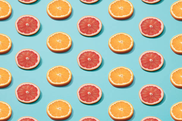 istock Slices of orange and grapefruit on a blue background. Minimal pattern. Copy space. 1307718194
