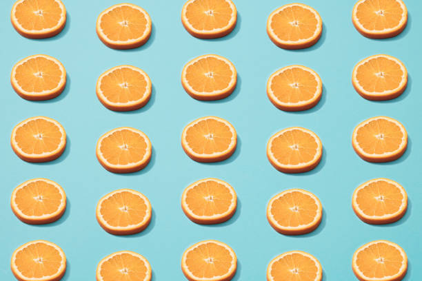 istock Slices of orange on blue background. Minimal pattern. 1307718245
