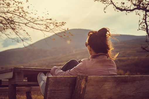 Beautiful woman relaxing in nature in sunset.