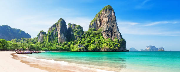 Panorama of beautiful sand Railay beach and thai traditional wooden longtail boat in Krabi province, Thailand. Panorama of beautiful sand Railay beach and thai traditional wooden longtail boat in Krabi province. Ao Nang, Thailand. koh poda stock pictures, royalty-free photos & images