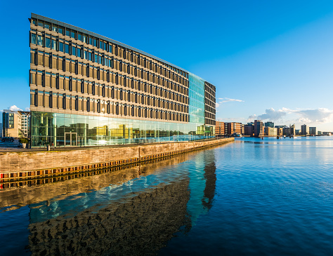Panoramic view at night across the modern office buildings and apartment blocks along the harbour waterfront in central Copenhagen, Denmark’s vibrant capital city.
