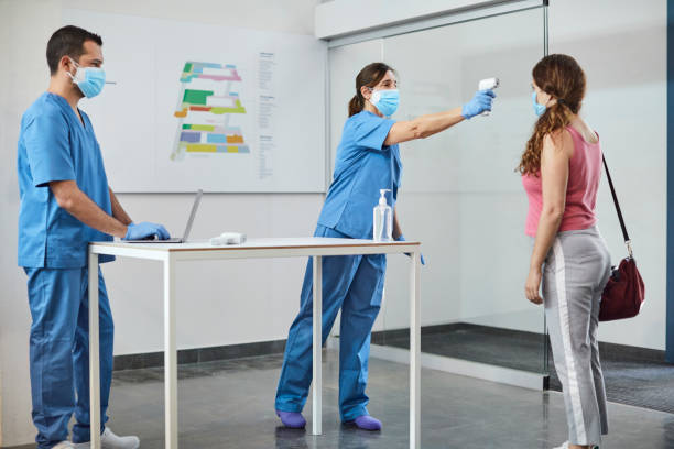 istock Nurse checking woman's temperature during COVID-19 1307721155