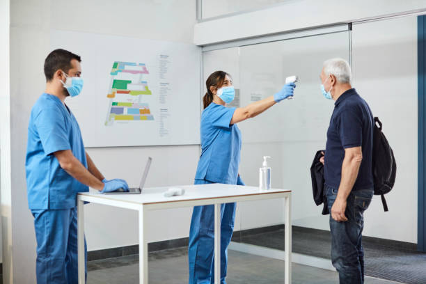 istock Nurse checking man's temperature during pandemic 1307721176