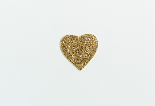 Golden glitter heart on the white background. Modern trendy minimalist Easter background
