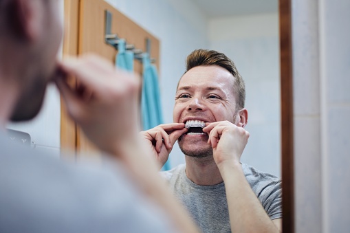 Hombre prepara bandeja de silicio para blanqueamiento dental photo