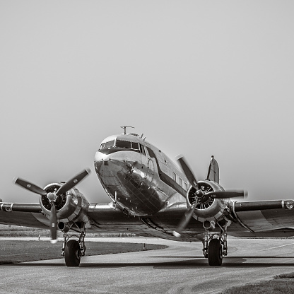Vintage Douglas DC-3 propellor airplane ready for take off at the runway of an empty airfield. Image with a retro look.