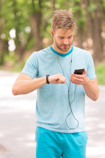 gadget bracelet. l’athlète vérifie le fond de nature de traqueur de forme physique. gadget de podomètre de regard d’athlète. entraînement sportif avec montre intelligente. configurer un tracker de remise en forme. entraîneur de fitness. paramètr - natural bristle audio photos et images de collection