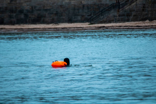 istock Cold water swimmer in wetsuit with inflatable 1307726509