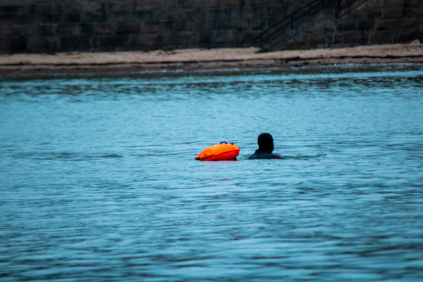 istock Cold water swimmer in wetsuit with inflatable 1307726573