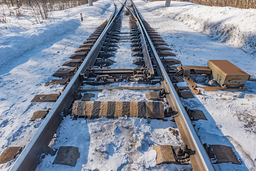 Railway tracks on the station at winter day time.