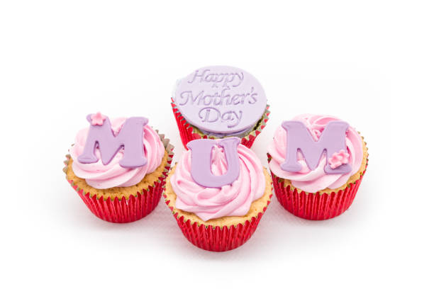 istock Three Pink Icing cupcakes with Swirled pink icing on plain sponge and contained in red sponge casing With MUM written on the front cakes and Happy mothers day on the rear cake 1307728251