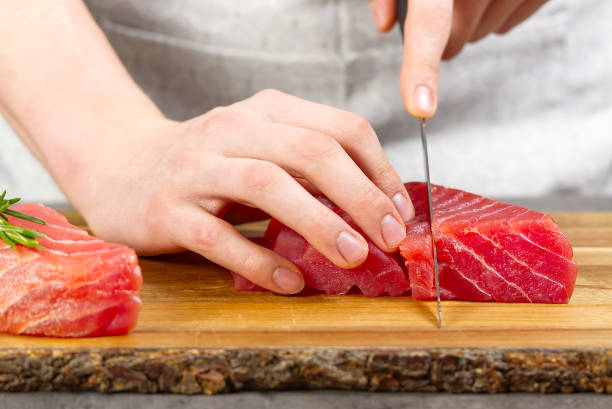 chef che fa sashimi in cucina, carne di tonno crudo fresco. dieta di pesce - prepared tuna foto e immagini stock