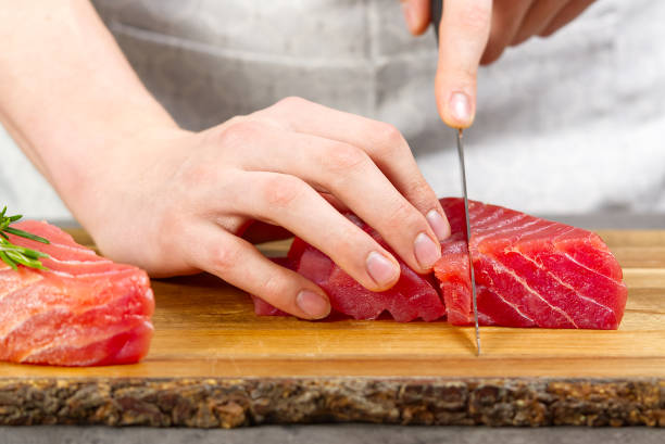 istock Chef making sashimi in kitchen, fresh raw tuna meat. seafood diet 1307728569