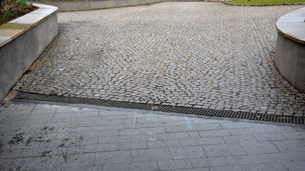 istock across the path there is a channel with a metal grid for drainage interlocking paving. the water is drained from the surface into the gutter and further into the rain sewer 1307728581