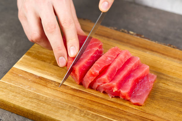 istock Chef making sashimi in kitchen, fresh raw tuna meat. seafood diet 1307728674