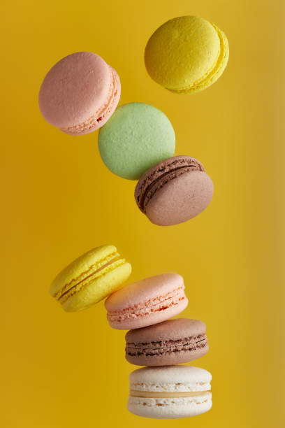 istock Macaroon. Colorful cake macaron with pastel tones fall at the stack macaroon on an yellow background. Top view of almond cookies. 1307728972