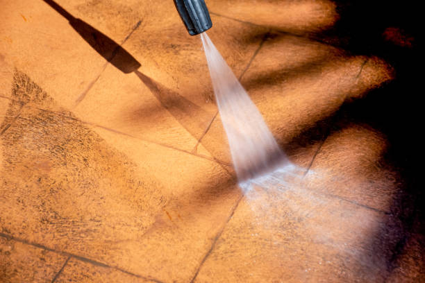 istock Cleaning backyard paving tiles with pressure washer. 1307731185