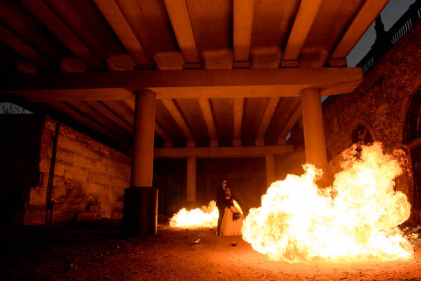 istock Halloween couple standing with flamethrower. big fire 1307731547