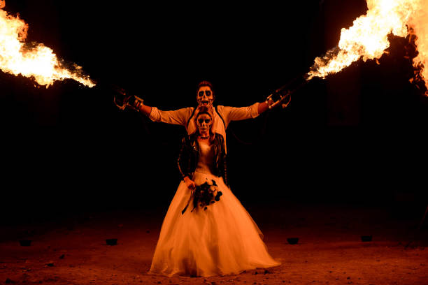 istock Halloween couple standing with flamethrower. big fire 1307731601