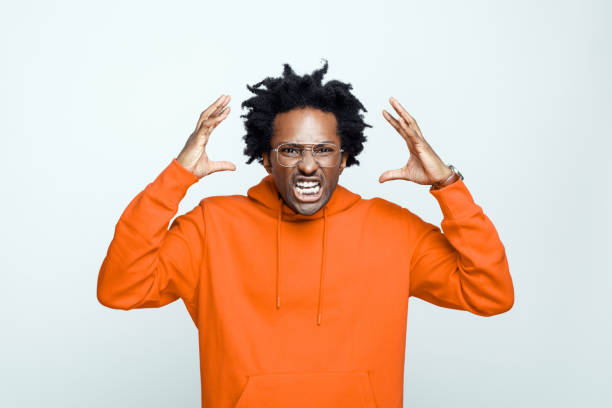 istock Angry man in orange hoodie 1307732100