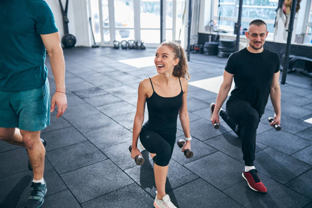 istock Smiling athletes doing the low lunge with dumbbells 1307733886