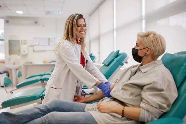 Woman Donating Blood In Hospital Donation Bank Woman donating blood in hospital donation bank during coronavirus pandemic. blood plasma stock pictures, royalty-free photos & images