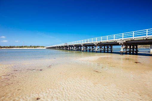 The idyllic Barwon River Beach and Barwon Heads Bridge on a hot summer's day in Barwon Heads, Victoria, Australia