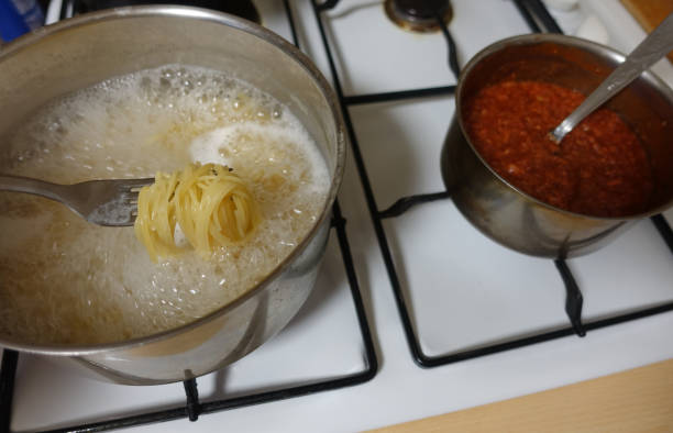 istock Spaghetti and bolognese sauce being cooked in saucepans 1307740901