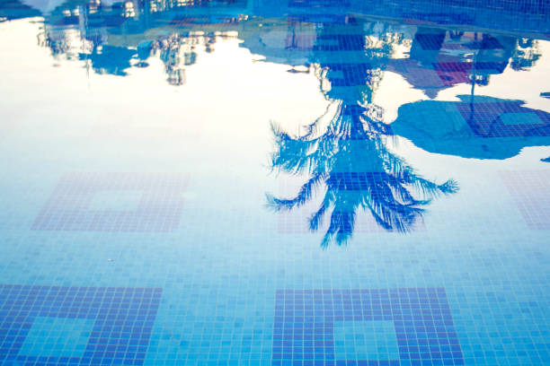 istock Reflection of palm trees and beach umbrellas in the pool 1307741473