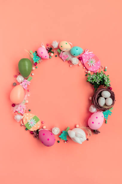 istock Circle wreath shape made of colorful spring flowers and eggs on pink background.  Easter celebration concept. Top view. Flat lay 1307742254