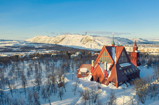 Kiruna Church from 1912, a landmark building built in wood in the town of Kiruna in the northern province of Lapland, Sweden. In the background is the iron mining operations in the town.