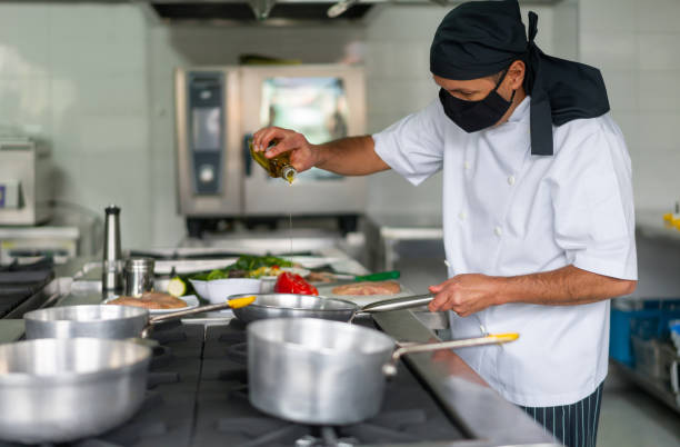 istock Chef wearing a facemask while cooking in the kitchen during the pandemic 1307746904