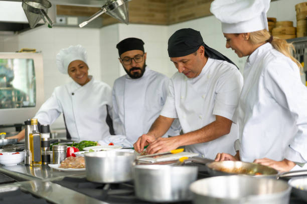 istock Cooks paying attention to the chef while taking cooking class 1307746908