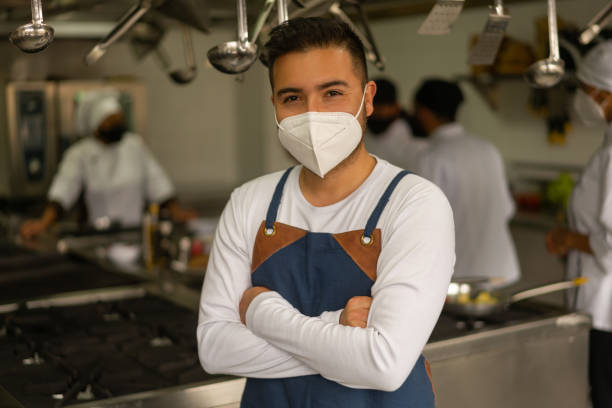 istock Man wearing a facemask in the kitchen while taking cooking lessons during the pandemic 1307746934