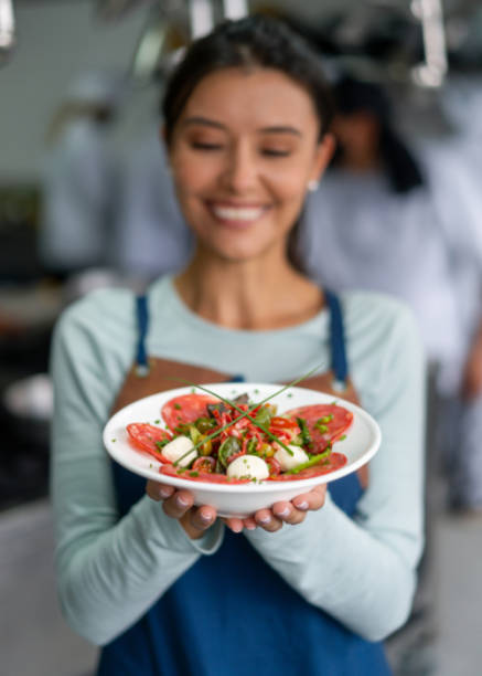 istock Happy woman presenting a plate in a cooking class 1307746939