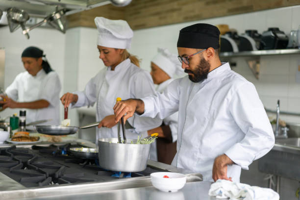 istock Chefs cooking together in a commercial kitchen at a restaurant 1307746962