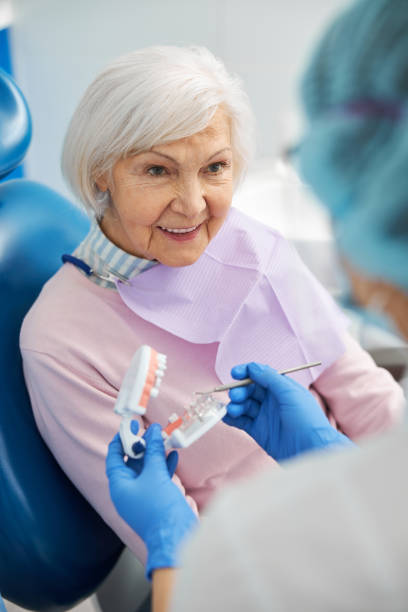 istock Interested pensioner looking at dentist with dental model 1307747055