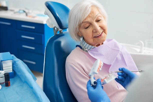 anziano che ascolta la spiegazione ortodontista dei denti umani - impianto dentale foto e immagini stock