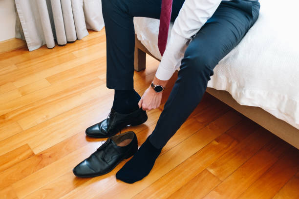 istock Young businessman putting on shoes 1307747249