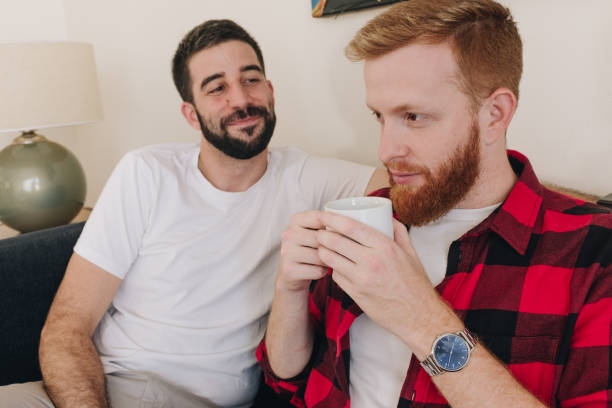 istock young man drinking tea while his partner looks at him in love 1307747291