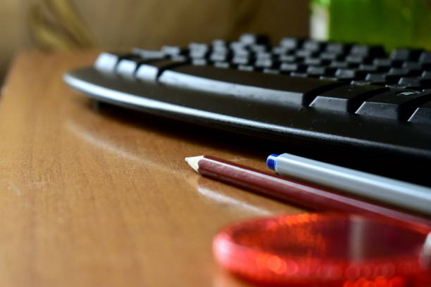 istock pencil and pen by the keyboard 1307747394