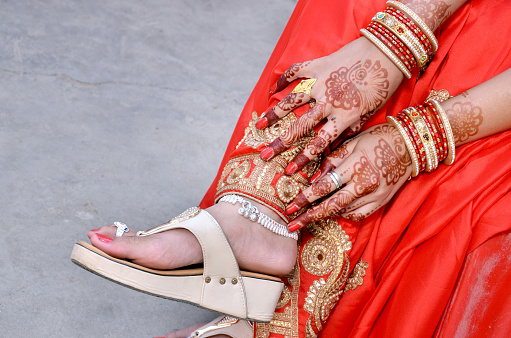 Indian bridal showing her footwear ,Payal and Mehandi on her wedding day